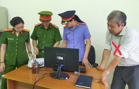 Bắt tạm giam hiệu trưởng và kế toán Trường Cao đẳng công nghiệp Thanh Hóa - Ảnh 2. Cơ quan chức năng thi hành lệnh khám xét nơi làm việc của bị can Nguyễn Giang Quân (bìa phải ảnh) - Ảnh Công an tỉnh Thanh Hóa cung cấp