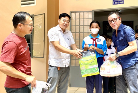 Trao trung thu cho trẻ 'nhà không chạm đất' - Ảnh 1. Ông Lâm Tấn Lợi - giám đốc Công ty Duy Lợi (phải) và ông Ngô Đăng Thành - trưởng Phòng Giáo dục và Đào tạo huyện Định Quán (trái) trao quà cho các em học sinh - Ảnh: NGỌC TRÂM