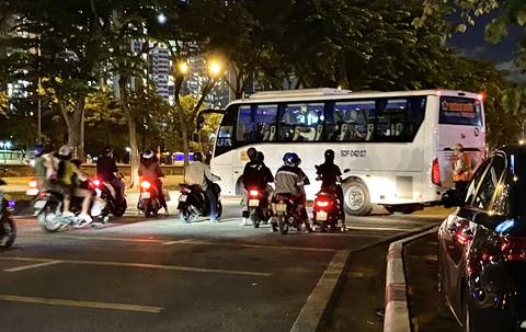 'Xe dù, bến cóc' rầm rộ ở đường Mai Chí Thọ cản trở giao thông - Ảnh 2. Khi xe ghế ngồi quay đầu, dòng người đi xe máy phải dừng chờ khá lâu.