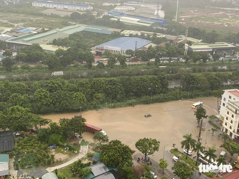 Đường phố Hà Nội ngập sâu vì mưa lớn, trời tối mịt như ban đêm - Ảnh 4. Đại lộ Thăng Long, đoạn giao đường Lê Trọng Tấn (cổng chào Thiên đường Bảo Sơn), xã An Khánh, Hoài Đức - Ảnh: THÀNH CHUNG