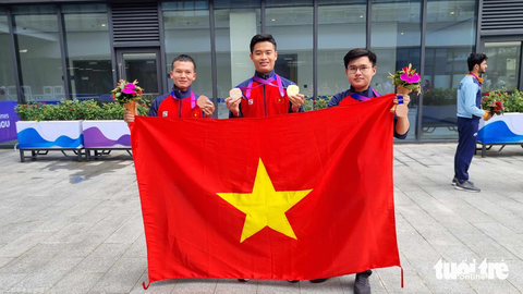 Asiad 19 ngày 28-9: Xạ thủ Quang Huy mang HCV đầu tiên về cho Việt Nam - Ảnh 3. Phạm Quang Huy và các đồng đội cầm cờ Việt nam ăn mừng huy chương tại Asiad 19 - Ảnh: HUY ĐĂNG