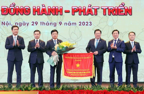 Tập đoàn nhà nước phải tập trung đầu tư lĩnh vực mũi nhọn, dẫn dắt xu thế mới - Ảnh 1. Phó thủ tướng Trần Hồng Hà tặng cờ thi đua của Chính phủ cho lãnh đạo Ủy ban Quản lý vốn nhà nước tại doanh nghiệp - Ảnh: M.K.