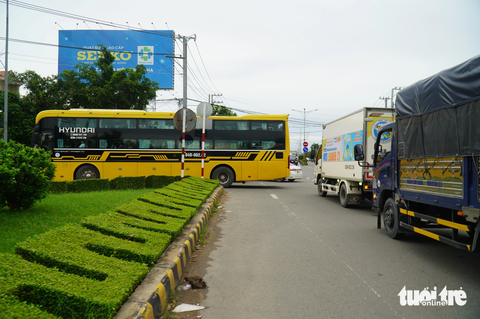 Người dân quay lại TP. HCM sớm, cầu Rạch Miễu lại kẹt cứng - Ảnh 2. Dòng xe từ Bến Tre qua Tiền Giang sau khi xuống khỏi cầu Rạch Miễu được hướng dẫn rẽ vào tuyến đường tránh thay vì chạy thẳng trên quốc lộ 60 - Ảnh: MẬU TRƯỜNG