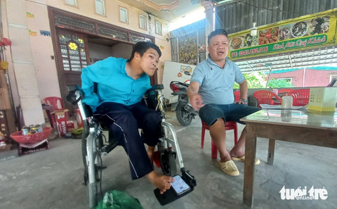 ‘Đứa em tật nguyền’ mòn mỏi gần 4 năm chờ...thi hành án - Ảnh 1. Anh Phạm Thanh Tùng (trái) sử dụng điện thoại mở tài liệu cho chúng tôi, còn anh Phạm Văn Sơn bức xúc kể - Ảnh: BỬU ĐẤU