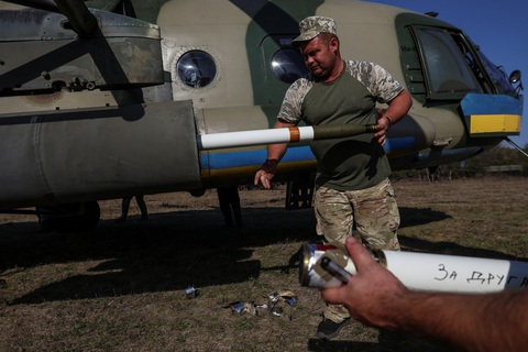Nga tố Ukraine bắn phá cả trăm lần mỗi ngày vào vùng biên giới - Ảnh 1. Binh sĩ Ukraine nạp rocket cho trực thăng Mi-8 ở mặt trận phía đông - Ảnh: REUTERS