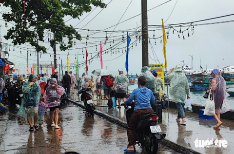 Nối lại các tuyến phà, tàu cao tốc từ đất liền đi Nam Du, Phú Quốc - Ảnh 2. Hay tin tàu cao tốc chạy lại, nhiều khách du lịch kẹt lại ở đảo Nam Du đã mặc áo mưa tranh thủ xuống tàu về lại đất liền - Ảnh: LÝ LỢI