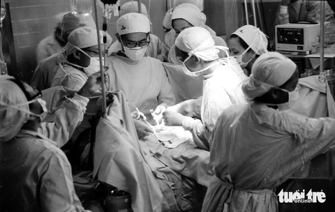 Giáo sư Văn Tần, người mổ tách cặp song sinh Việt - Đức, qua đời - Ảnh 2. Bác sĩ Văn Tần (đứng giữa), bác sĩ Trần Đông A (phải), bác sĩ Trần Thành Trai (trái) cùng ê kíp ca phẫu thuật tách đôi cặp song sinh dính liền Việt – Đức tại Bệnh viện Từ Dũ ngày 4-10-1988 - Ảnh: NGUYỄN CÔNG THÀNH