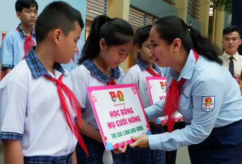 'Thiếu nhi thành phố Bác chăm ngoan, học tốt, tiếp bước cha anh' - Ảnh 2. Chị Trịnh Thị Hiền Trân, phó bí thư Thành Đoàn TP.HCM, chủ tịch Hội đồng Đội thành phố, trao học bổng cho các em học sinh có hoàn cảnh khó khăn - Ảnh: K.ANH