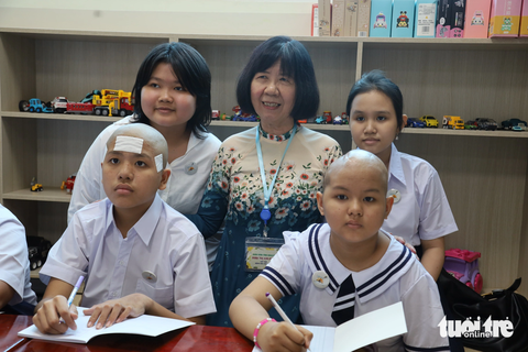 Niềm vui khai giảng của bệnh nhi ung thư - Ảnh 2. Cô Đinh Thị Kim Phấn cùng bệnh nhi ung thư trong ngày khai giảng - Ảnh: NGUYÊN KHANG