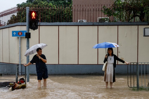 Mưa kỷ lục ở Hong Kong, Thâm Quyến do bão Haikui gây ra ra sao? - Ảnh 5. Người dân phải bám vào các tay vịn để dò bước đi do dòng nước mưa quá mạnh ngày 8-9 ở Hong Kong - Ảnh: REUTERS