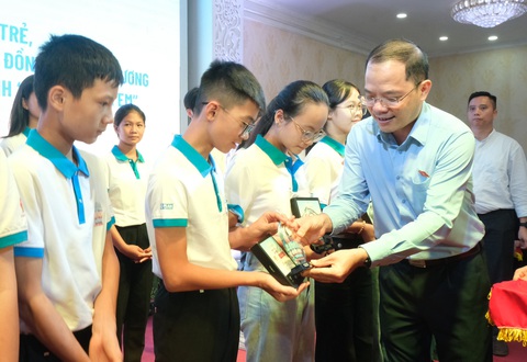 Nhóm đại biểu Quốc hội trẻ gặp mặt 263 bạn nhỏ 'đại biểu Quốc hội' giả định - Ảnh 2. Ông Đinh Công Sỹ - phó chủ nhiệm Ủy ban Văn hóa Giáo dục của Quốc hội, phó chủ tịch thường trực nhóm đại biểu Quốc hội trẻ - tặng quà cho các bạn nhỏ thiếu nhi - Ảnh: HÀ THANH