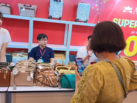 “Săn” hàng hiệu giá hời - Ảnh 5. Một nữ khách hàng gọi video quay chi tiết từng chiếc túi để tham khảo ý kiến mua hàng - Ảnh: NHẬT XUÂN