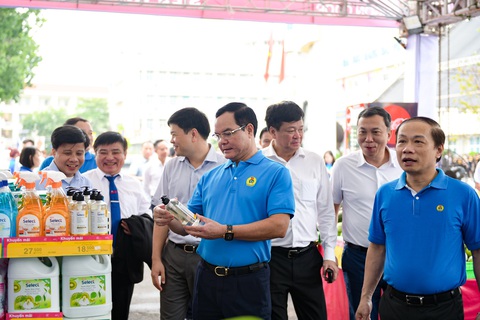 Chính thức khai mạc Giải Vô địch bóng đá công nhân toàn quốc 2023 - Ảnh 6. Ông Nguyễn Đình Khang - chủ tịch Tổng liên đoàn Lao động Việt Nam - xem một mặt hàng tại gian hàng của Saigon Co.op