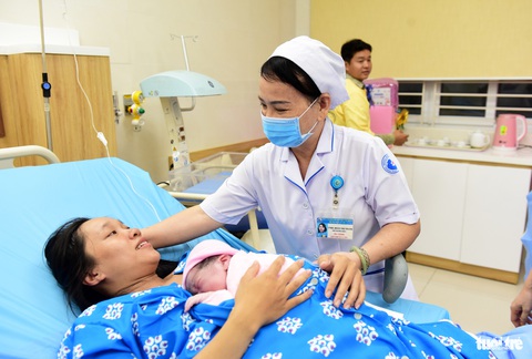 Chào đón công dân đầu tiên của năm mới 2024- Ảnh 3. Hộ sinh Đoàn Thị Thanh chia vui cùng sản phụ - Ảnh: DUYÊN PHAN