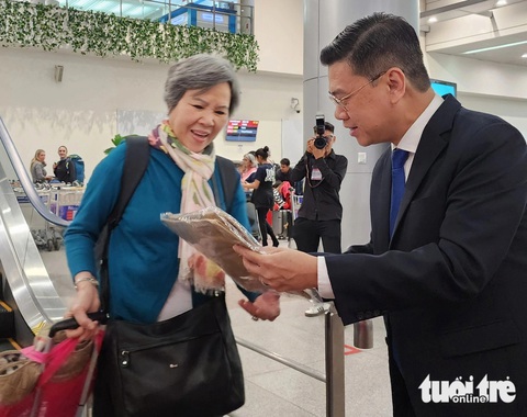 Du khách xông đất TP.HCM năm mới được tặng vé máy bay khứ hồi, quà lưu niệm- Ảnh 1. Phó chủ tịch UBND TP.HCM Nguyễn Văn Dũng tặng quà lưu niệm cho du khách xông đất TP.HCM đầu năm 2024 - Ảnh: HẢI KIM
