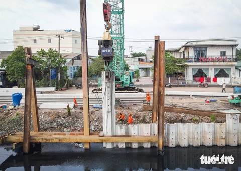 Trên công trường cải tạo kênh dài nhất TP.HCM ngày đầu năm 2024- Ảnh 1. Tại gói thầu XL3, công nhân đang đóng hoàn thiện kè bờ phía huyện Bình Chánh - Ảnh: CHÂU TUẤN