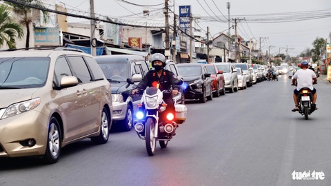 Kẹt xe khi trở lại TP.HCM, tài xế phải kêu phở ăn lúc chờ qua phà Cát Lái- Ảnh 4. Cảnh sát giao thông có mặt từ sớm điều tiết, tránh tình trạng lấn làn mất trật tự tại phà Cát Lái - Ảnh: TIẾN QUỐC