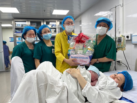 Chào đón công dân đầu tiên của năm mới 2024- Ảnh 11. Ông Đinh Anh Tuấn (bìa phải) tặng quà cho gia đình bé Nghị ngay sau khi đón bé chào đời - Ảnh: HỒNG HÀ