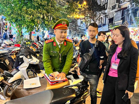 Trông xe 'chặt chém' đêm đón năm mới, hàng chục trường hợp bị phạt 7,5 triệu đồng- Ảnh 1. Cảnh sát lập biên bản một bãi trông xe vi phạm - Ảnh: H.Q.
