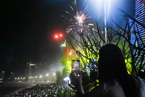 Chen nhau chật kín bãi biển Nha Trang đón năm mới 2024- Ảnh 7. Nhiều người dùng điện thoại chụp lại pháo hoa