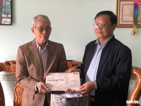 Thăm và tặng tập tư liệu quý hiếm cho các 'nhân chứng Hoàng Sa'- Ảnh 4. Lãnh đạo UBND huyện Hoàng Sa tặng tập Tư liệu Hoàng Sa cho cụ Trương Văn Quảng, một nhân chứng từng sống tại Hoàng Sa - Ảnh: MINH NGUYỆT