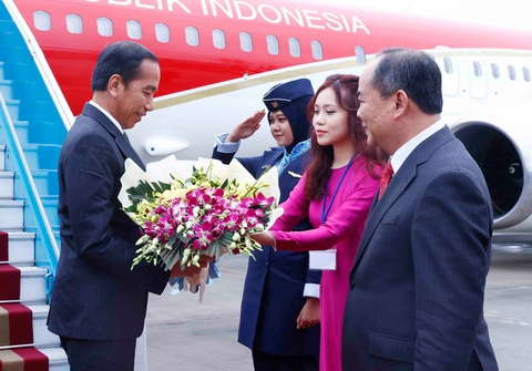 Tổng thống Indonesia Joko Widodo bắt đầu thăm Việt Nam- Ảnh 2. Tổng thống Indonesia Joko Widodo nhận bó hoa chào mừng khi đến sân bay Nội Bài chiều 11-1 - Ảnh: TTXVN
