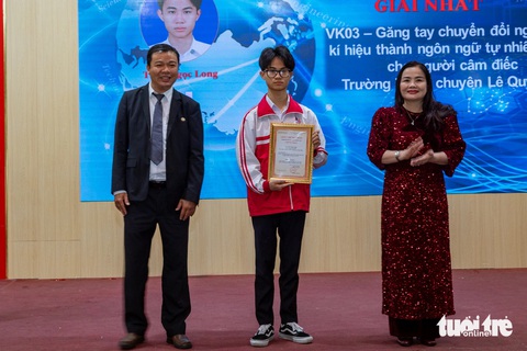 Học sinh lớp 11 chế tạo găng tay chuyển ngữ cho người khiếm thính- Ảnh 1. Em Trần Ngọc Long nhận giải nhất cho dự án găng tay chuyển đổi ngôn ngữ ký hiệu - Ảnh: HOÀNG TÁO