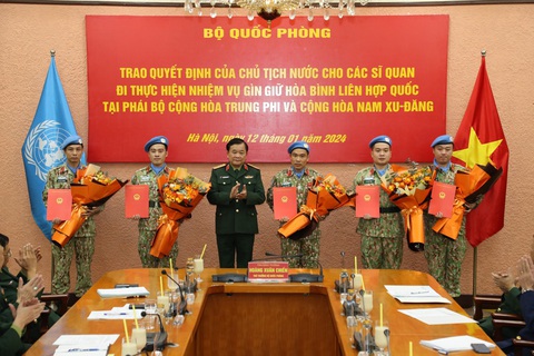 5 sĩ quan 'mũ nồi xanh' nhận quyết định đi gìn giữ hòa bình Liên Hiệp Quốc- Ảnh 1. Thượng tướng Hoàng Xuân Chiến trao quyết định của Chủ tịch nước cho các sĩ quan đi thực hiện nhiệm vụ gìn giữ hòa bình Liên Hiệp Quốc - Ảnh: MẠNH HÙNG