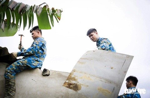 Bộ trưởng Phan Văn Giang tặng bằng khen cho phi công lái Su-22 ở Quảng Nam- Ảnh 1. Chiến sĩ Sư đoàn không quân 372 sửa chữa mái tôn nhà dân bị hư hại sau vụ rơi máy bay Su-22 tại thị xã Điện Bàn, tỉnh Quảng Nam - Ảnh: C.S.