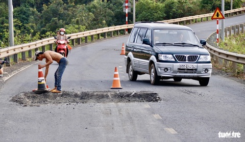 Sửa đường không rào chắn, tạo ra hàng chục 'hố bom' bẫy người đi đường- Ảnh 4. Thấy người chụp ảnh, đơn vị thi công mới cho đặt trụ cảnh báo - Ảnh: TIẾN QUỐC