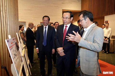 'Thương hiệu tôi yêu': Sống cùng những cảm xúc, khoảnh khắc của người tiêu dùng- Ảnh 2. Ông Trần Xuân Toàn, phó tổng biên tập báo Tuổi Trẻ, giới thiệu với Bí thư Thành ủy Nguyễn Văn Nên các bài viết tham dự cuộc thi "Thương hiệu tôi yêu" - Ảnh: HỮU HẠNH