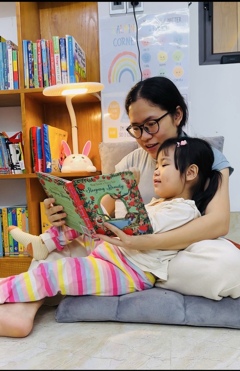 Cha mẹ rủ nhau cùng con ‘Đặt điện thoại xuống, cầm sách lên’- Ảnh 1. Học được từ hội thảo về một trong những tư thế đọc sách hiệu quả với con trẻ là ôm con vào lòng cùng đọc, chị Lê Thị Thúy Phương (Hà Giang) thực hành cùng con và thấy ngay được sự thay đổi khi ngày nào con cũng có nhu cầu đọc sách cùng mẹ - Ảnh: Tác giả cung cấp