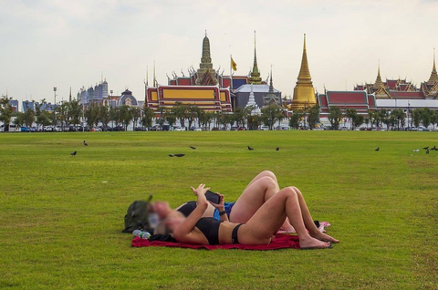 Mặc đồ lót tắm nắng trước cung điện, hai cô gái bị chỉ trích nặng nề- Ảnh 1. Bức ảnh 2 cô gái mặc đồ lót thể thao tắm nắng ở quảng trường Sanam Luang khiến dư luận Thái Lan tranh cãi - Ảnh: FACEBOOK