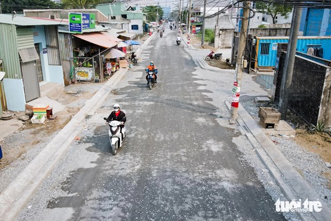 Đường nát ở TP.HCM 'lột xác' đón Tết- Ảnh 2. Mặt đường Hồ Văn Long nay đã bằng phẳng, những ổ gà ổ voi trước đây đã được san lấp