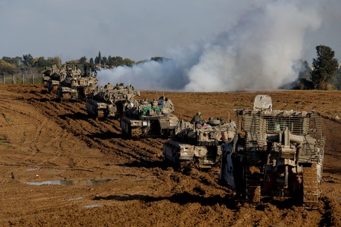 Các xe quân sự của Israel di chuyển ra khỏi Dải Gaza. Ảnh chụp nhìn từ miền nam Israel vào ngày 15-1 - Ảnh: REUTERS