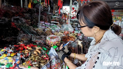 Chợ Đông Ba treo thưởng 500.000 đồng cho người phát hiện tiểu thương 'chặt chém'- Ảnh 3. Một tiểu thương ở chợ Đông Ba thực hiện việc niêm yết giá lên mặt hàng móc khóa, đồ lưu niệm - Ảnh: NHẬT LINH