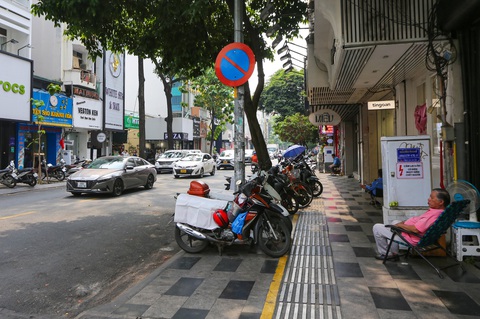 Vướng quy định về thu phí lòng đường, vỉa hè, TP.HCM kiến nghị hướng dẫn- Ảnh 1. Vỉa hè ở đường Nguyễn Trãi, quận 1 đã được kẻ vạch, chia chỗ để xe máy tự quản - Ảnh: CHÂU TUẤN