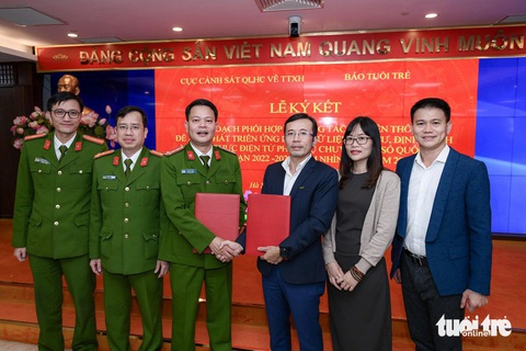 Cục C06 Bộ Công an và báo Tuổi Trẻ ký hợp tác truyền thông đề án 06- Ảnh 4. Phó cục trưởng Cục C06 Bộ Công an Vũ Văn Tấn, Phó tổng biên tập báo Tuổi Trẻ Trần Xuân Toàn và các đại biểu tham dự buổi lễ ký kết - Ảnh: NAM TRẦN
