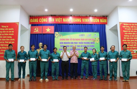 Ba thế hệ vẫn quyết bám giữ rừng sác- Ảnh 1. Phó giám đốc Sở Thông tin và Truyền thông TP.HCM (áo trắng) cùng viện trưởng Viện nghiên cứu phát triển Phương Đông (áo hồng) trao quà cho các hộ giữ rừng - Ảnh: CẨM NƯƠNG