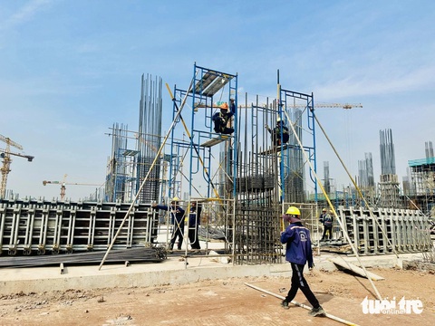 Nhà ga T3 Tân Sơn Nhất vốn 11.000 tỉ đồng sẽ là 'thành phố hàng không'- Ảnh 1. Công nhân nhộn nhịp làm việc tại dự án xây dựng nhà ga hành khách T3 Tân Sơn Nhất. Chủ đầu tư cam kết sẽ hoàn thành, vận hành khai thác vào tháng 6-2025 - Ảnh: CÔNG TRUNG