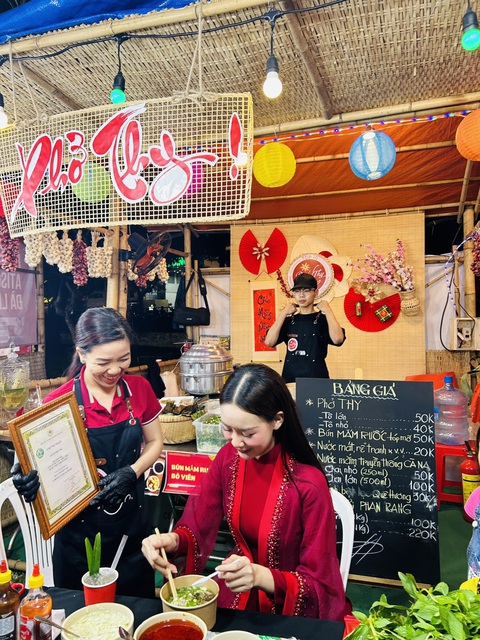Ngày của phở 12-12 nhận bằng khen tôn vinh tinh hoa ẩm thực Việt- Ảnh 5. Hoa hồi vàng Khánh Thy khoe bằng chứng nhận Ngày của phở 12-12 với hoa hậu Bảo Ngọc tại quầy phở Thy - Ảnh: MINH HUỲNH