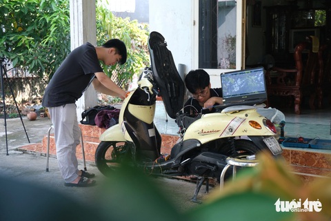 Sinh viên chế tạo hệ thống tự động chống cháy nổ xe máy- Ảnh 1. Trần Nhật Thanh Huy và Huỳnh Nguyễn Anh Kiệt nghiên cứu trên xe máy của gia đình - Ảnh: NGỌC PHƯỢNG