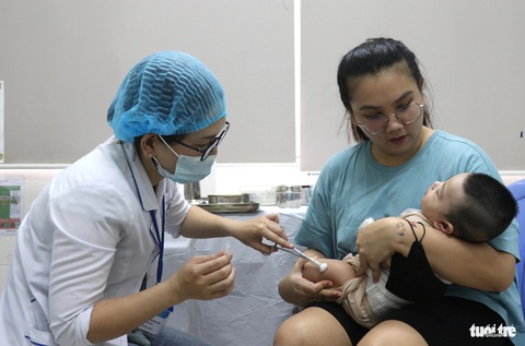 Vắc xin 5 trong 1 về trạm, phụ huynh vui mừng khi trẻ không phải đi tiêm dịch vụ- Ảnh 4. Trẻ được phụ huynh đưa đến Trạm y tế phường Phú Mỹ (quận 7) tiêm vắc xin sau khi được rà soát, gọi điện thoại gọi mời - Ảnh: XUÂN MAI