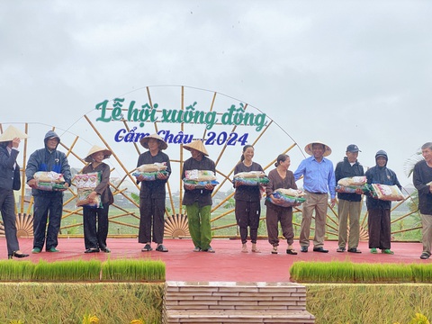 Khách Tây khoái chí xuống ruộng tát nước, cấy lúa cùng nông dân Hội An- Ảnh 2. Nông dân được mời lên sân khấu để tặng lúa giống, phân bón hữu cơ trong lễ hội xuống đồng đầu năm - Ảnh: B.D.