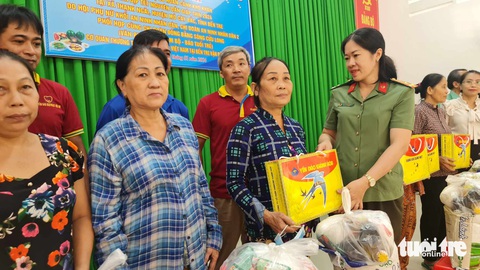 Báo Tuổi Trẻ trao 70 phần quà cho bà con nghèo ở Bến Tre- Ảnh 2. Thượng tá Nguyễn Thị Thanh Thương, phó trưởng Phòng an ninh chính trị nội bộ Công an tỉnh Bến Tre, trao quà cho bà con có hoàn cảnh khó khăn - Ảnh: MẬU TRƯỜNG