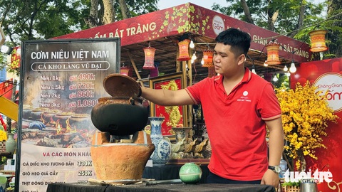 Thưởng thức thịt heo bản, cá kho làng Vũ Đại, bún nước lèo Sóc Trăng ở Lễ hội Tết Việt- Ảnh 1. Anh Bằng nấu cá kho làng Vũ Đại ngay tại lễ hội - Ảnh: PHƯƠNG QUYÊN