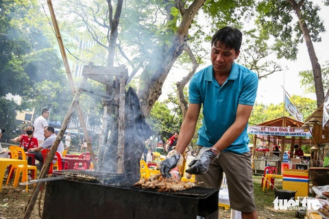 Thưởng thức thịt heo bản, cá kho làng Vũ Đại, bún nước lèo Sóc Trăng ở Lễ hội Tết Việt- Ảnh 5. Thịt heo bản chuyển từ Điện Biên về ướp và nướng ngay tại lễ hội - Ảnh: PHƯƠNG QUYÊN