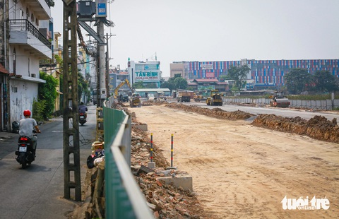 Đập bức tường tồn tại 3 thập kỷ, gỡ tắc đường vào sân bay Tân Sơn Nhất- Ảnh 1. Bức tường có tuổi đời hơn 30 năm ngăn cách sân bay Tân Sơn Nhất và khu dân cư trước kia đã được tháo dỡ, thay thế tạm bằng rào chắn tôn để bảo vệ người dân đi ngang qua công trình xây dựng đường nối Trần Quốc Hoàn - Cộng Hòa, mở rộng thênh thang cho xe cộ vào nhà ga sân bay - Ảnh: CHÂU TUẤN