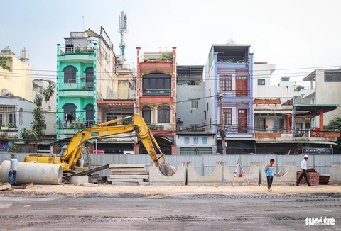 Đập bức tường tồn tại 3 thập kỷ, gỡ tắc đường vào sân bay Tân Sơn Nhất- Ảnh 4. Các công nhân, kỹ sư và máy móc đang hoạt động tấp nập bên trong rào chắn công trường xây dựng đường nối Trần Quốc Hoàn với khu dân cư