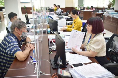 Áp thuế cao với người nhiều nhà, đất: Khó nhưng phải làm- Ảnh 5. Bà Đỗ Thị Cẩm Tú (chuyên viên chi nhánh Văn phòng đăng ký đất đai quận Phú Nhuận, TP.HCM) tiếp người dân đến làm thủ tục về nhà đất vào sáng 19-1 - Ảnh: T.T.D.